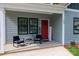 Inviting front porch featuring a seating area and a vibrant red front door at 2302 Jordi Way, Charlotte, NC 28213