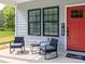 Inviting front porch with seating, bright red front door, and attractive black window trim at 2302 Jordi Way, Charlotte, NC 28213