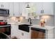 Charming kitchen boasts white cabinets, a black sink, and stainless steel appliances at 2302 Jordi Way, Charlotte, NC 28213