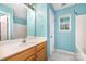 A light blue bathroom features a sink, window, and door, ready for updating at 248 Pangle Dr, Charlotte, NC 28217
