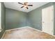 This bedroom features a ceiling fan, bare floors, and bland green paint at 248 Pangle Dr, Charlotte, NC 28217