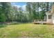 Spacious backyard with a lawn and wooded area beyond the deck at 2586 Lee Lawing Rd, Lincolnton, NC 28092