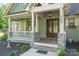 Inviting covered front porch with stone accents and double wood doors at 2586 Lee Lawing Rd, Lincolnton, NC 28092
