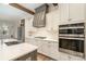 Bright kitchen features white cabinets, gray vent hood, stainless appliances, gas cooktop and large kitchen island at 2586 Lee Lawing Rd, Lincolnton, NC 28092