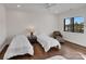 Well-lit bedroom with two twin beds, hardwood flooring, ceiling fan, and large windows at 264 Fairway Shores Rd, Mount Gilead, NC 27306