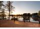 Wooden deck overlooking calm lake waters at sunset, framed by trees and featuring a sleek railing at 264 Fairway Shores Rd, Mount Gilead, NC 27306