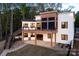 Rear exterior view featuring a deck, patio, stairs, and modern architectural design at 264 Fairway Shores Rd, Mount Gilead, NC 27306