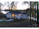 Aerial view of modern lake house with dock and landscaped yard at sunset near lake at 264 Fairway Shores Rd, Mount Gilead, NC 27306
