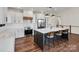 Modern kitchen with white cabinets, stainless steel appliances, large center island with seating and hardwood floors at 264 Fairway Shores Rd, Mount Gilead, NC 27306
