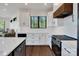 Modern kitchen boasts white cabinets, quartz countertops, stainless steel appliances, and wood accents at 264 Fairway Shores Rd, Mount Gilead, NC 27306