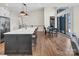 Open concept kitchen with island seating, hardwood floors, and a dining area near large glass doors at 264 Fairway Shores Rd, Mount Gilead, NC 27306