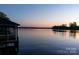 A serene lake view with a colorful sunset sky reflecting on the calm water's surface at 264 Fairway Shores Rd, Mount Gilead, NC 27306