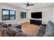Cozy living room with a large TV, comfortable seating, and scenic lake views from the windows at 264 Fairway Shores Rd, Mount Gilead, NC 27306