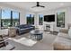 Living room with hardwood floors, modern furniture, ceiling fan and large windows overlooking the lake at 264 Fairway Shores Rd, Mount Gilead, NC 27306