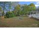 Private backyard with an outdoor firepit, lush lawn, screened-in porch, and spacious deck for relaxation at 300 Yacht Rd, Mooresville, NC 28117
