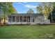 Manicured backyard featuring spacious deck, screened-in porch with outdoor seating, and lush green lawn at 300 Yacht Rd, Mooresville, NC 28117