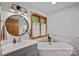 Elegant bathroom with freestanding tub, modern vanity, round mirror, and natural light at 300 Yacht Rd, Mooresville, NC 28117
