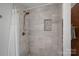 Updated tiled shower features a modern shower head, built-in niche, and glass door at 300 Yacht Rd, Mooresville, NC 28117
