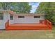 Back of the house featuring a painted wood deck, white painted brick and green backyard at 3108 Anne St, Charlotte, NC 28205