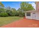 Exterior rear view from a painted wood deck with an entrance door looking out on the green lawn at 3108 Anne St, Charlotte, NC 28205