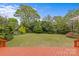 Large green lawn backyard with a painted wood deck looking over the manicured garden and trees at 3108 Anne St, Charlotte, NC 28205