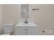 Bathroom featuring a white vanity, toilet and framed mirror over the vanity at 3108 Anne St, Charlotte, NC 28205