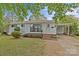 Charming one-story home with white brick, new windows, front yard with green lawn and landscaped features at 3108 Anne St, Charlotte, NC 28205