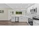 Modern kitchen with stainless steel appliances, island with sink and white cabinets, with view to yard at 3108 Anne St, Charlotte, NC 28205