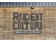 Rustic wooden sign of Resident Culture Brewing Company with bold lettering and industrial feel at 3108 Anne St, Charlotte, NC 28205