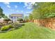 Large backyard with lush green grass, wooden fence, playset, and view of the home at 3831 Robeson Creek Dr, Charlotte, NC 28270