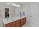 Bright bathroom features a large mirror, double sink vanity with wood cabinets, and neutral paint at 3831 Robeson Creek Dr, Charlotte, NC 28270