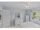 Bright bedroom with white furniture, including a bed, nightstand, dresser, desk, and a window for natural light at 3831 Robeson Creek Dr, Charlotte, NC 28270