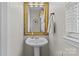 Clean half bathroom featuring a pedestal sink, decorative mirror, and neutral colors, offering a functional space at 3831 Robeson Creek Dr, Charlotte, NC 28270