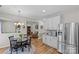 Bright kitchen with white cabinets, stainless steel appliances, and adjacent dining area with hardwood floors at 3831 Robeson Creek Dr, Charlotte, NC 28270