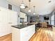 Bright kitchen features a center island with granite countertop, white cabinets, and hardwood flooring at 3914 Cassidy Dr, Waxhaw, NC 28173