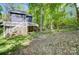 Backyard of home with stairs leading to a deck, surrounded by trees at 4036 Windward Dr, Tega Cay, SC 29708