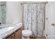 Bright bathroom with a granite-style sink, shower with floral curtain, and white door at 4036 Windward Dr, Tega Cay, SC 29708