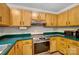 Cozy kitchen features wood cabinets, stainless steel oven and teal countertops at 4036 Windward Dr, Tega Cay, SC 29708