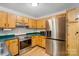Bright kitchen features wood cabinets, stainless steel appliances and wood floors at 4036 Windward Dr, Tega Cay, SC 29708