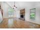 Open living room with wood flooring and a cozy stone fireplace at 4036 Windward Dr, Tega Cay, SC 29708