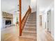 View of a carpeted staircase adjacent to the living room with stone fireplace at 4036 Windward Dr, Tega Cay, SC 29708