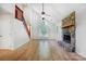 Spacious living room with wood floors, stone fireplace, and staircase at 4036 Windward Dr, Tega Cay, SC 29708