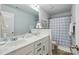 Bright bathroom featuring double sinks, a large mirror, and a blue and white patterned shower curtain at 4040 Lauren Elizabeth Dr, Rock Hill, SC 29732
