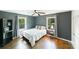 This bedroom features hardwood floors, two windows and a ceiling fan at 4313 Sudbury Rd, Charlotte, NC 28205