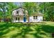 Charming two-story home with lush green lawn and mature trees, a blue front door, and freshly painted white brick at 4313 Sudbury Rd, Charlotte, NC 28205