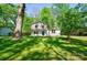 Charming two-story home with a manicured lawn, mature shade trees and a bright blue front door at 4313 Sudbury Rd, Charlotte, NC 28205