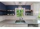 This modern kitchen features a stainless steel sink, window and floating shelves at 4313 Sudbury Rd, Charlotte, NC 28205