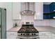 A modern kitchen features a stainless steel range, a range hood and light gray countertops at 4313 Sudbury Rd, Charlotte, NC 28205