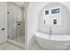 Modern bathroom with a glass-enclosed shower, a soaking tub, and a stylish faucet at 5010 Ohm Ln, Charlotte, NC 28270