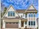 New construction with a light-colored brick, dark window frames, and beautiful architecture against a gorgeous blue sky at 5010 Ohm Ln, Charlotte, NC 28270